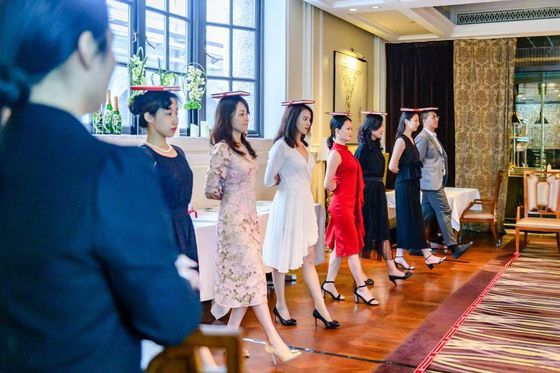 Participants practising posture and deportment in a salon