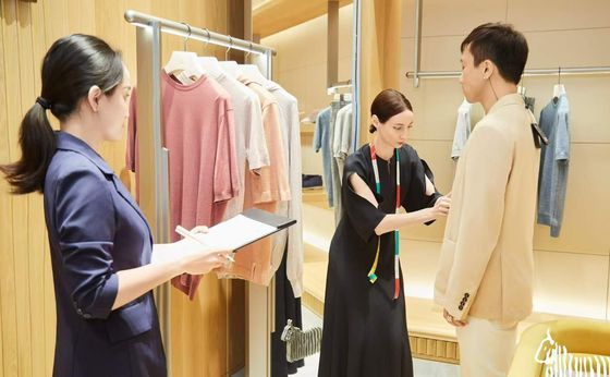 Stylist advising a client on an outfit in a boutique